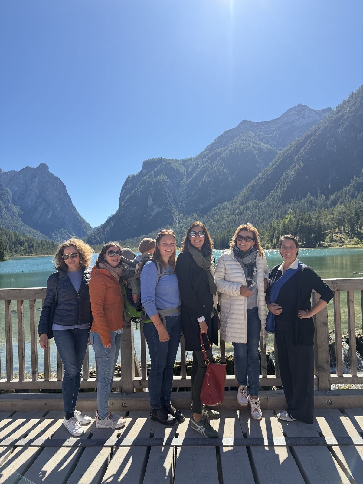 Die Runde auf einem Steg am Bergsee vor den Dolomiten