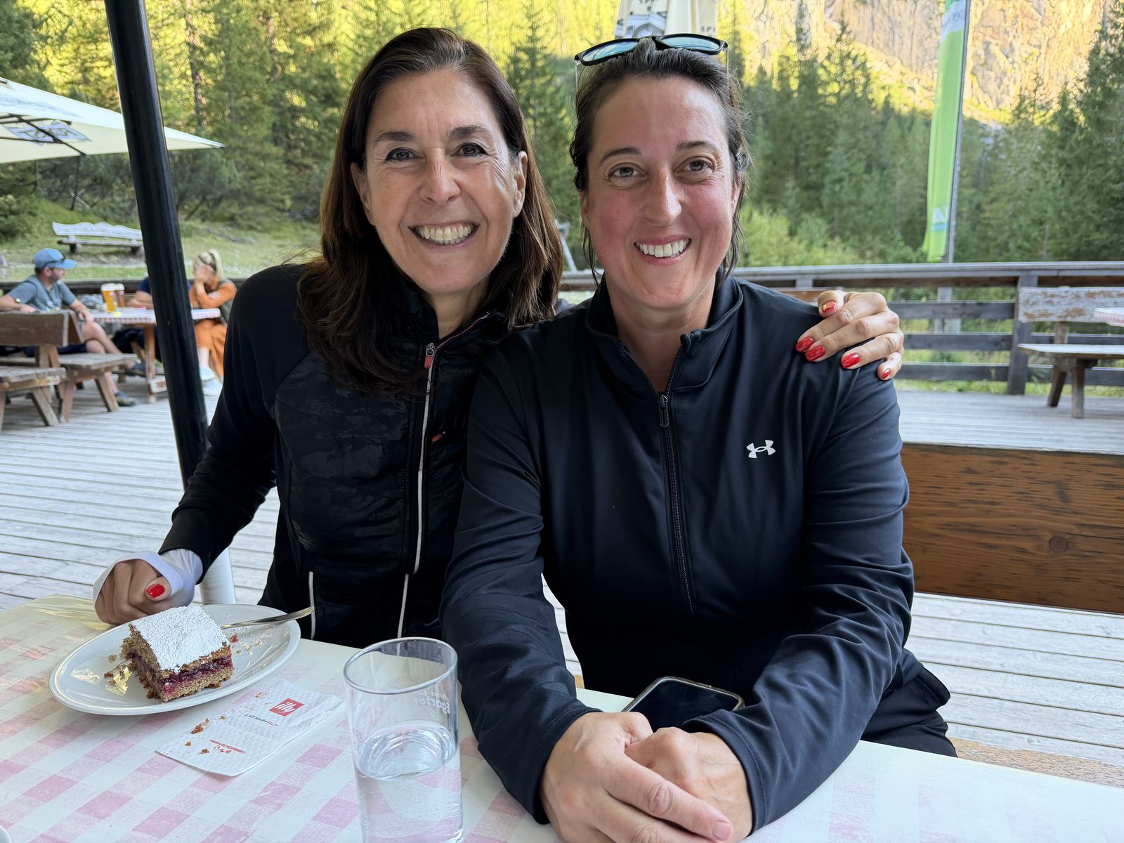 Jasmin Soravia mit einer Teilnehmerin bei Kuchen auf der Hütte